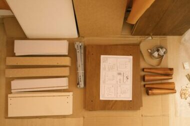 Flat lay of a DIY furniture assembly kit with instructions and tools.